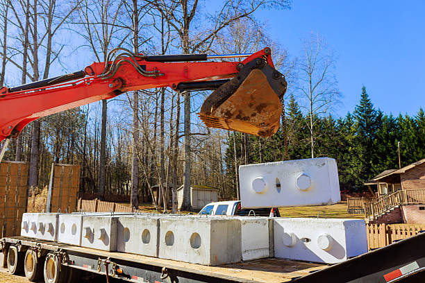 construction equipment is lifting concrete blocks at worksite rural area